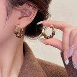 A model wearing the earrings, demonstrating their elegance and versatility.