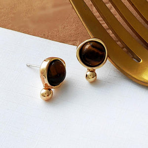 Detailed shot of Tiger Eye Earrings Studs on a textured surface